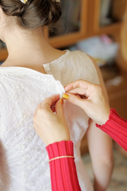 Helping the bride to put her wedding dress on