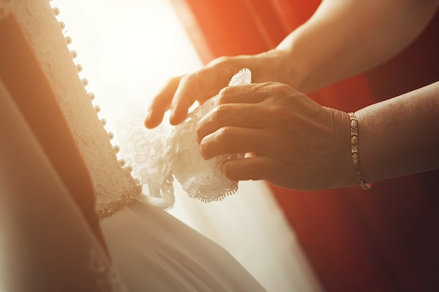 Helping the bride to put her wedding dress on