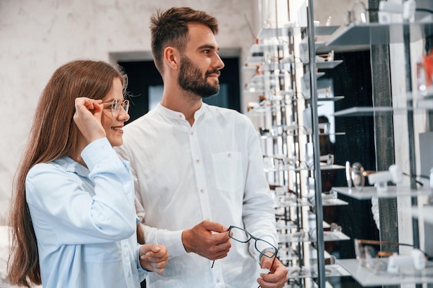 Helping to choose product Man and woman in the glasses store