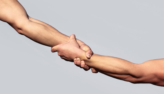 Helping hand concept and international day of peace support\
helping hand outstretched isolated arm salvation close up help hand\
two hands helping arm of a friend teamwork