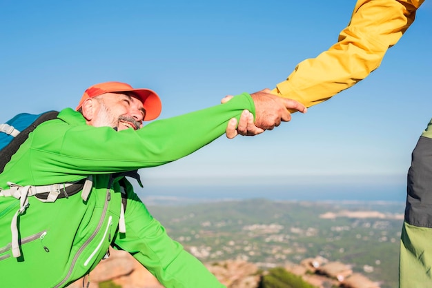 Helping hand hiker man getting help on hike happy overcoming obstacle