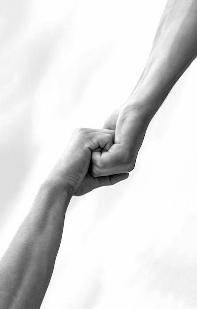 Photo helping hands concept support close up help arm and international day of peace support hands of on blue sky background black and white