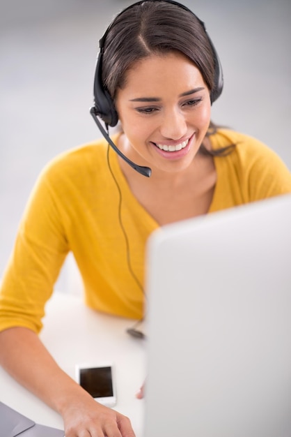 Helping her clients with finesse. shot of a young customer service representative wearing a headset while sitting by her computer