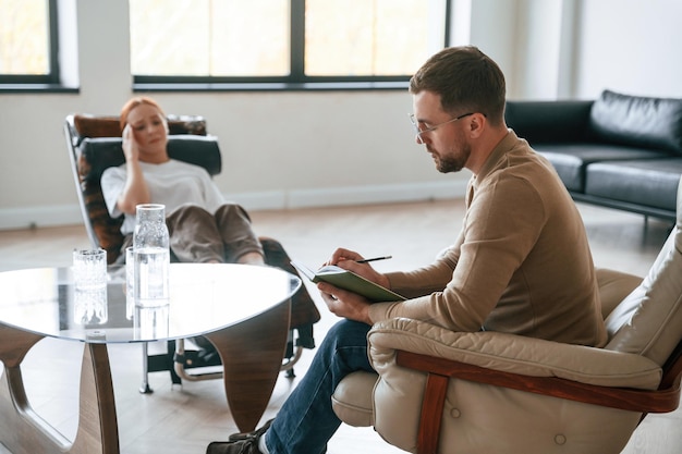 Helping the patient Woman is sitting in chair at an appointment with a psychologist