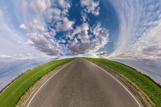 Hemisphere of the planet on an asphalt road stretching beyond the horizon with blue sky and beautiful clouds Spherical abstract aerial view Curvature of space