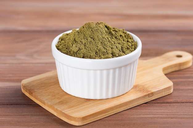 Hemp protein in a bowl on a wooden board