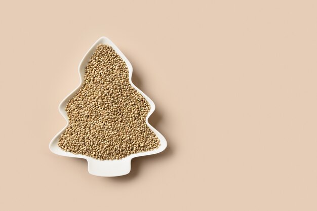 Hemp seeds in plate shape of christmas tree xmas vertical eco greeting card