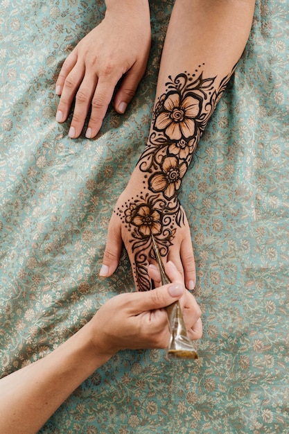 Photo henna tattoo on woman hands artist drawing arabic mehndi