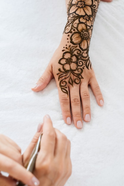 Henna tattoo on woman hands artist drawing arabic mehndi