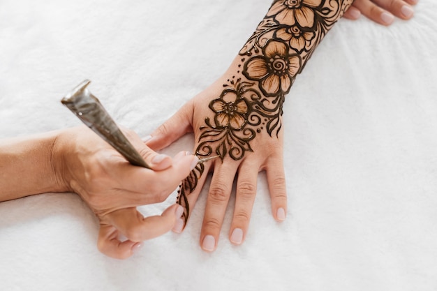 Henna tattoo on woman hands artist drawing arabic mehndi