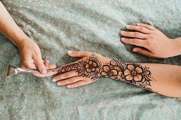 Photo henna tattoo on woman hands artist drawing arabic mehndi