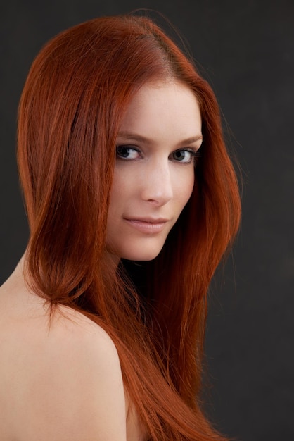 Her beauty is a light in the darkness Portrait of a gorgeous young redheaded woman against a black background