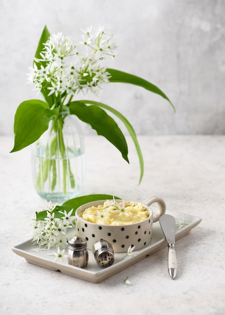 Herb butter with wild garlic flowers lemon juice pepper and salt in a ceramic bowl