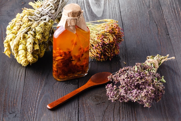 Herb-flavored oil on dark wood table