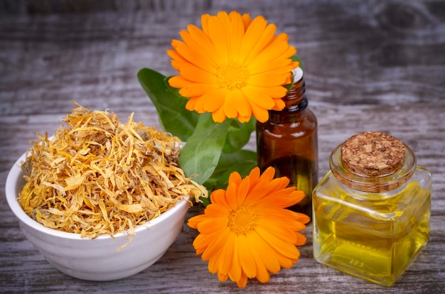 Herbal calendula officinalis in the glass and drop oil Isolated