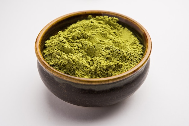 Photo herbal henna or mehandi powder in a bowl forming heap, used for tattoo or hair dye