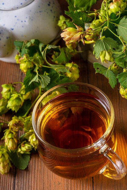 Чай из травяных шишек хмеля и цветов Органический сырой альтернативный горячий напиток со свежими шишками хмеля на деревянном столе