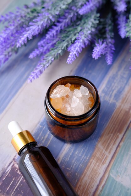 Herbal lavender salt and essential oil on table