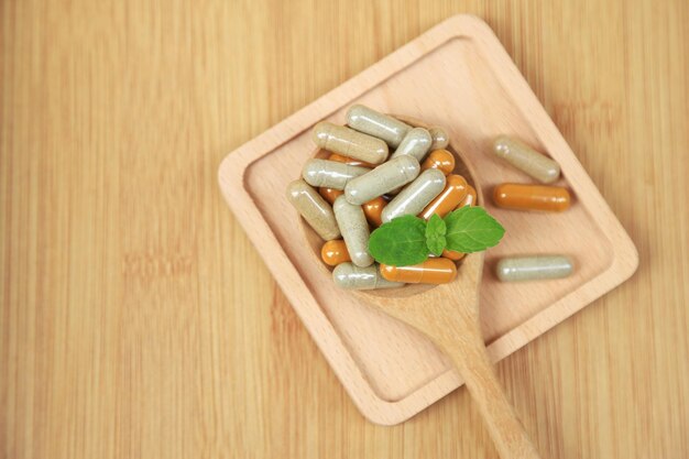 Herbal medicine in capsules from moringa leaf on rustic wooden table with copy space for medical background healthy eating with natural product for good living