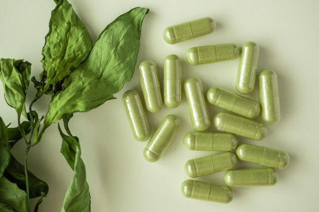 Herbal medicine capsules with Andrographis paniculata leaf on white background