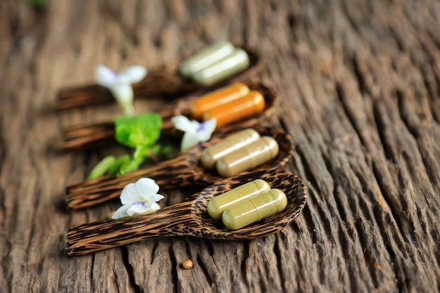 Herbal medicine capsules on wooden table