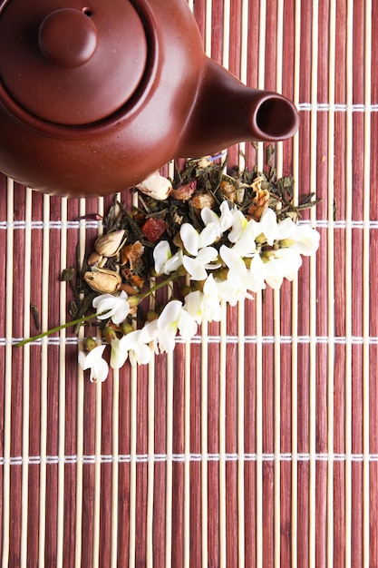 Herbal natural floral tea infusion with dry flowers ingredients on bamboo mat background