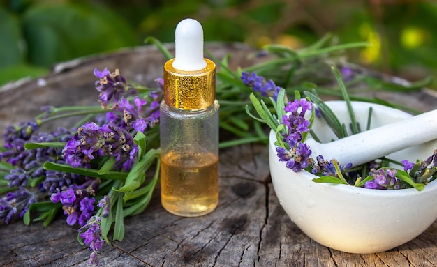 Herbal oil and lavender flowers on a wooden background Nature