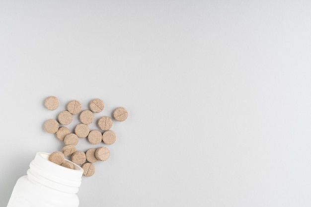 Herbal pills on gray background flat lay with copy space