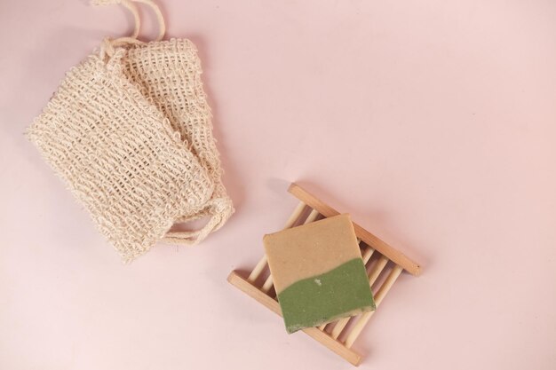 herbal soap and soap bag on color background