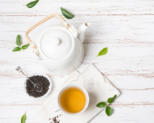 Фото Травяной чай чашка с сушеными травами и чайник на белом фоне текстурированных
