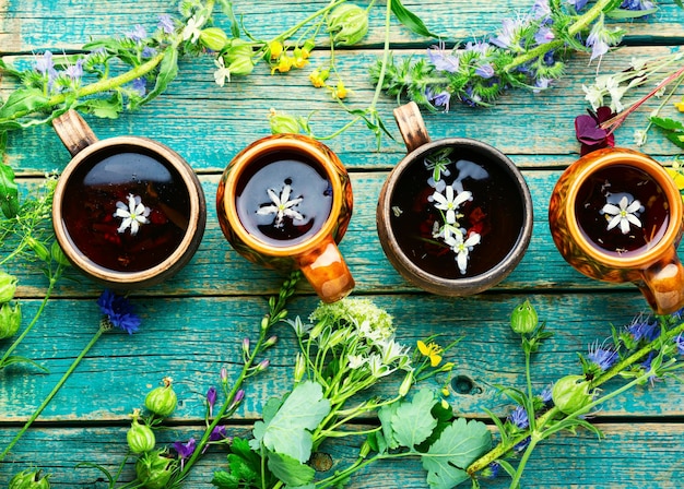 Травяной чай из полевых цветов на старом старинном деревянном столе. Фитотерапия, фитотерапия