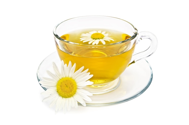 Herbal tea in a glass cup with daisies isolated 