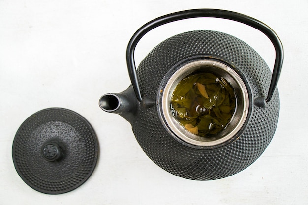 Herbal tea, iron teapot and cup of tea  