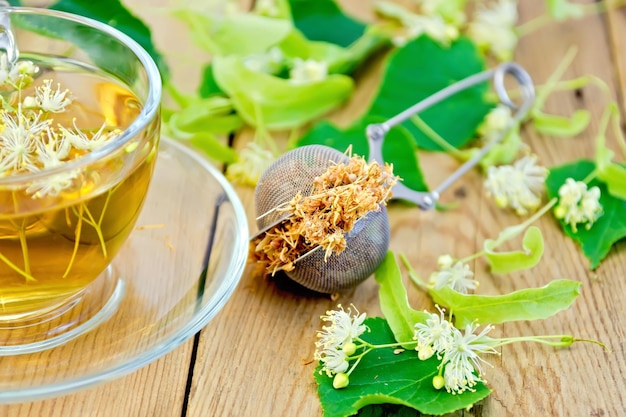 Herbal tea of linden flowers in strainer with cup