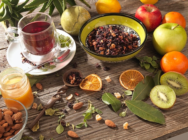 Herbal tea with berries and dried fruits on wooden table and warm light