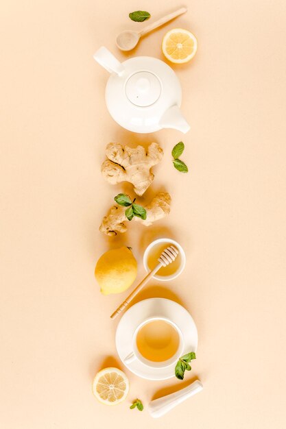 Herbal tea with mint ginger lemon honey and other herbs on yellow background Flat lay top view