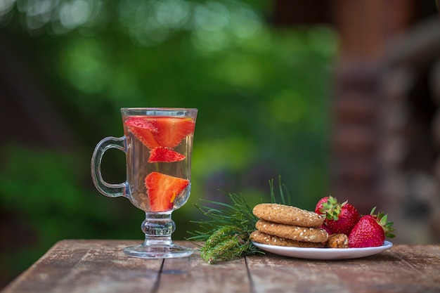 Tisana con fragole rosse sul tavolo, primo piano. il concetto di uno stile di vita sano.