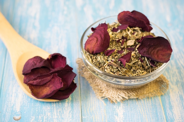 Herbal tea with rose petals on a rustic table.