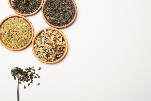 Photo herbal wellness dried tea on wooden round dishes against white background