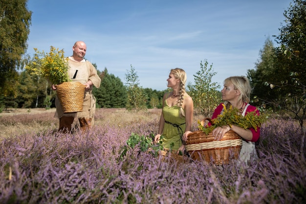 An herbalist with a basket of goldenrod herbs talks to her
friends in a forest clearing