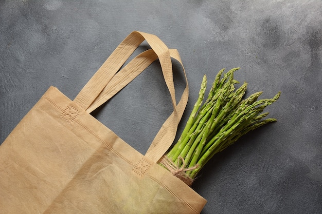 Herbruikbare afvalzak van textiel, gevuld met groene asperges