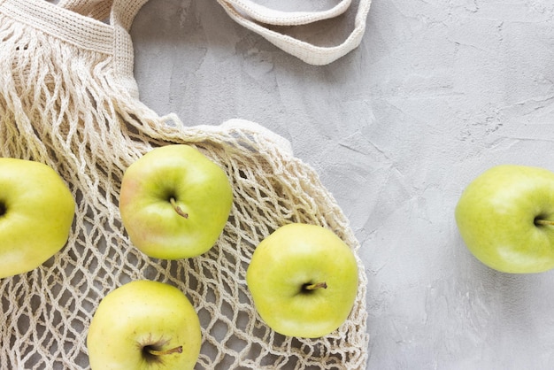 Herbruikbare boodschappentas op grijs met appelachtergrond Geen afval geen plastic