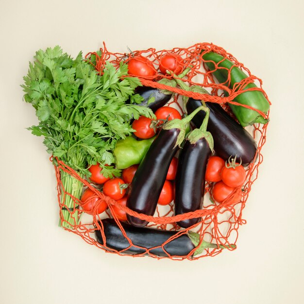 Herbruikbare netzak om te winkelen met het close-up bovenaanzicht van ecogroenten. Heldere, verse, smakelijke milieuvriendelijke groenten