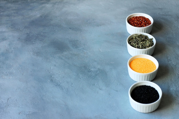 Herbs, cereals and seeds in a bowl on a gray concrete background