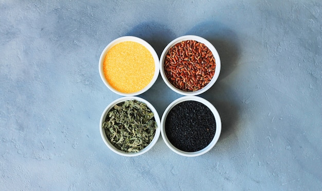 Herbs, cereals and seeds in a bowl on a gray concrete background