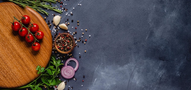 Herbs and condiments on black stone background. Top view with copy space.