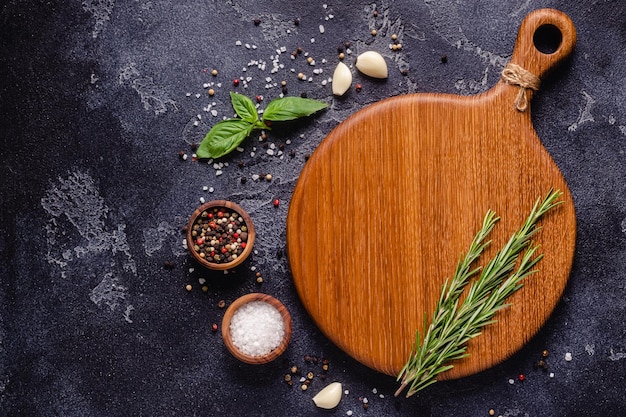 Herbs and condiments on black stone background. Top view with copy space.