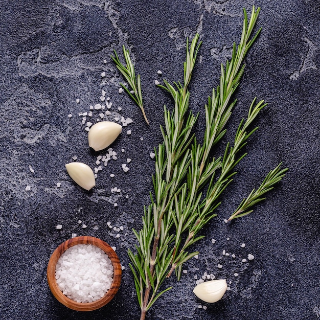 Herbs and condiments on black stone background Top view with copy space