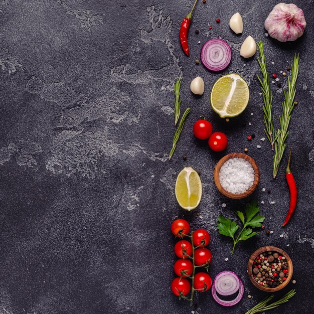 Herbs and condiments on black stone background Top view with copy space