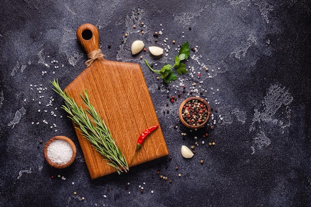 Herbs and condiments on black stone background